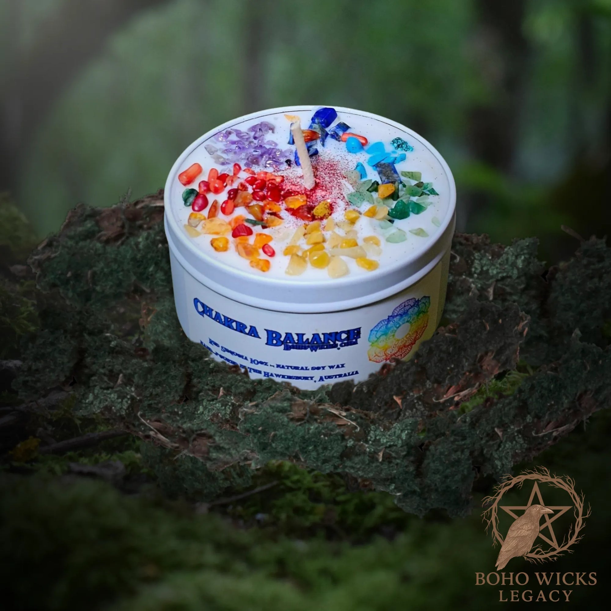 Forest setting photo of the Chakra Balance candle with seven colour layers surrounded by moss, fragranced with Clementine & Mimosa