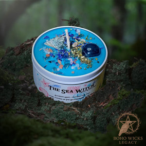 Forest setting photo of The Sea Witch candle with Fluorite, Cornflowers, Skullcap, Seashells, and Sea Salt surrounded by moss, fragranced with Alchemy