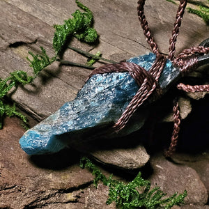 Blue apatite pendant wrapped in brown cord and leather