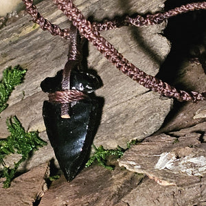 Close-up of obsidian arrowhead wrapped in cord