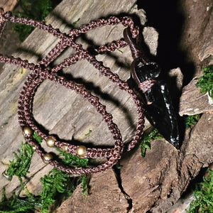 Black obsidian pendant resting on moss and wood