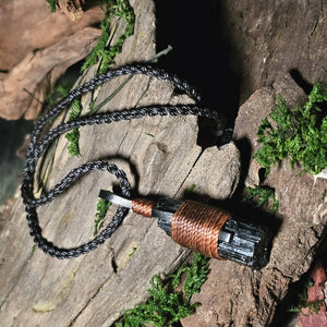 Close-up of black tourmaline crystal necklace on wood