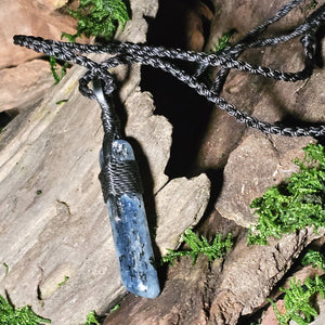 Blue kyanite pendant on rustic wood with black woven cord