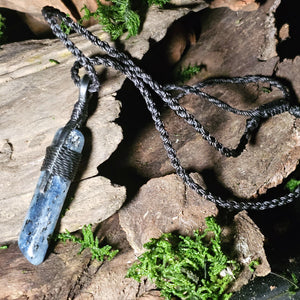 Glossy kyanite necklace staged on natural forest textures
