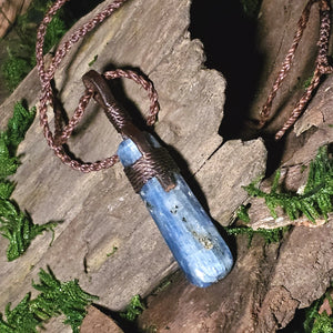 Blue kyanite crystal pendant styled with nature elements and earth tones