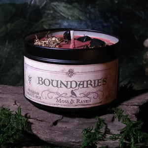 Candle labeled 'Boundaries' by Moss & Raven on a natural background