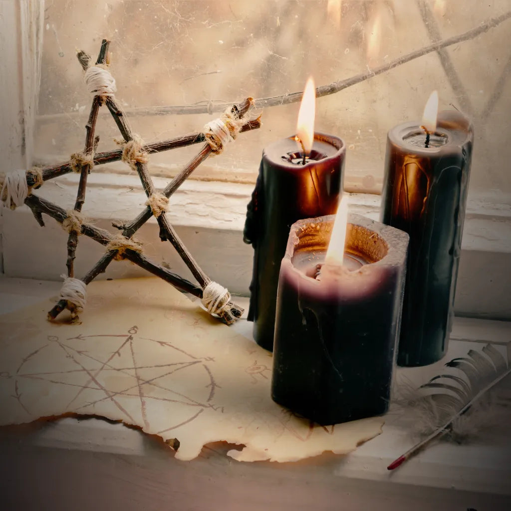 Burning black candles, twig pentacle, and elemental sigil on altar paper – detail from Moss & Raven meditation space