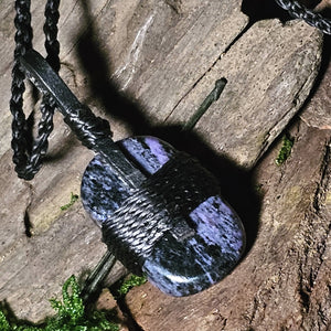 Purple and black charoite crystal in woven pendant form