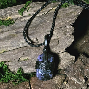 Crystal pendant featuring purple charoite and leather wrap