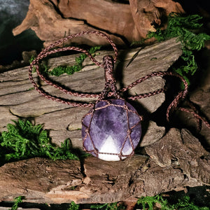 Close-up of chevron amethyst in macrame wrap on wood