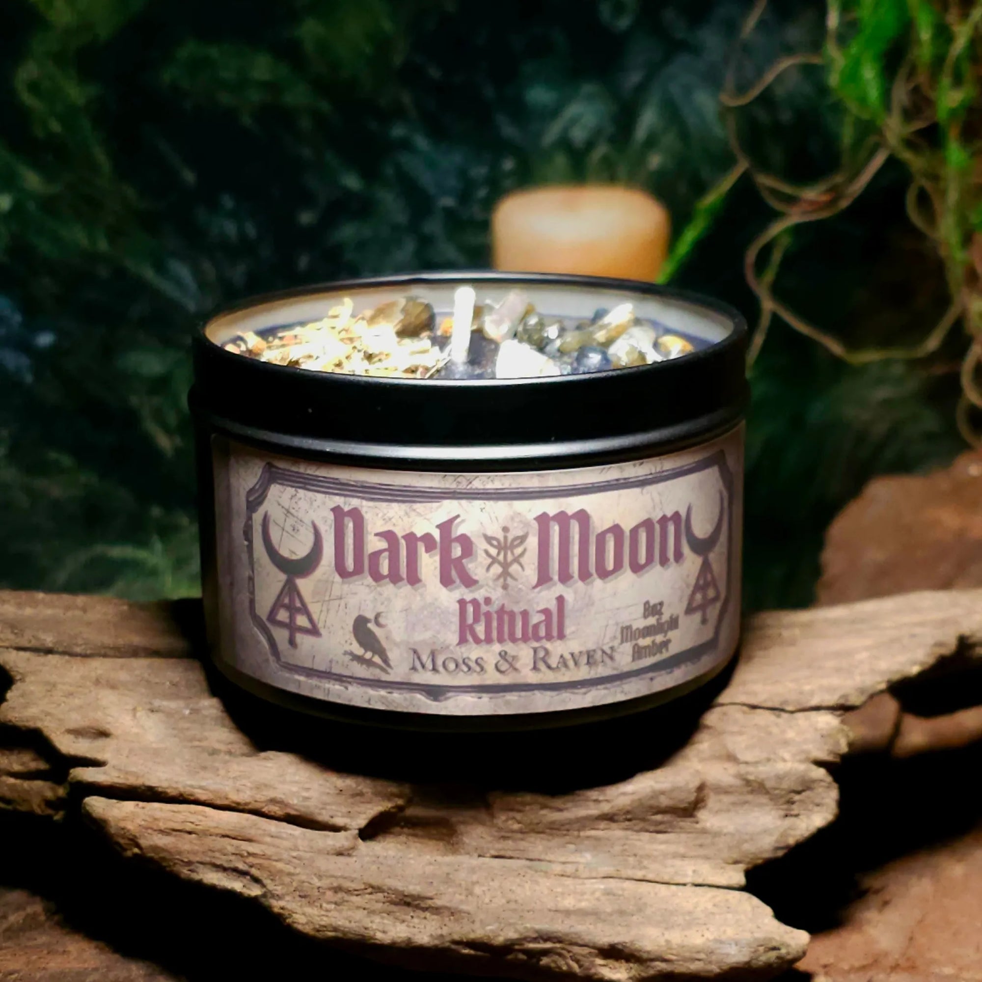 Dark Moon Ritual Candle by Moss & Raven – black wax candle in black tin, dressed with labradorite chips, myrrh resin, mugwort, and wormwood