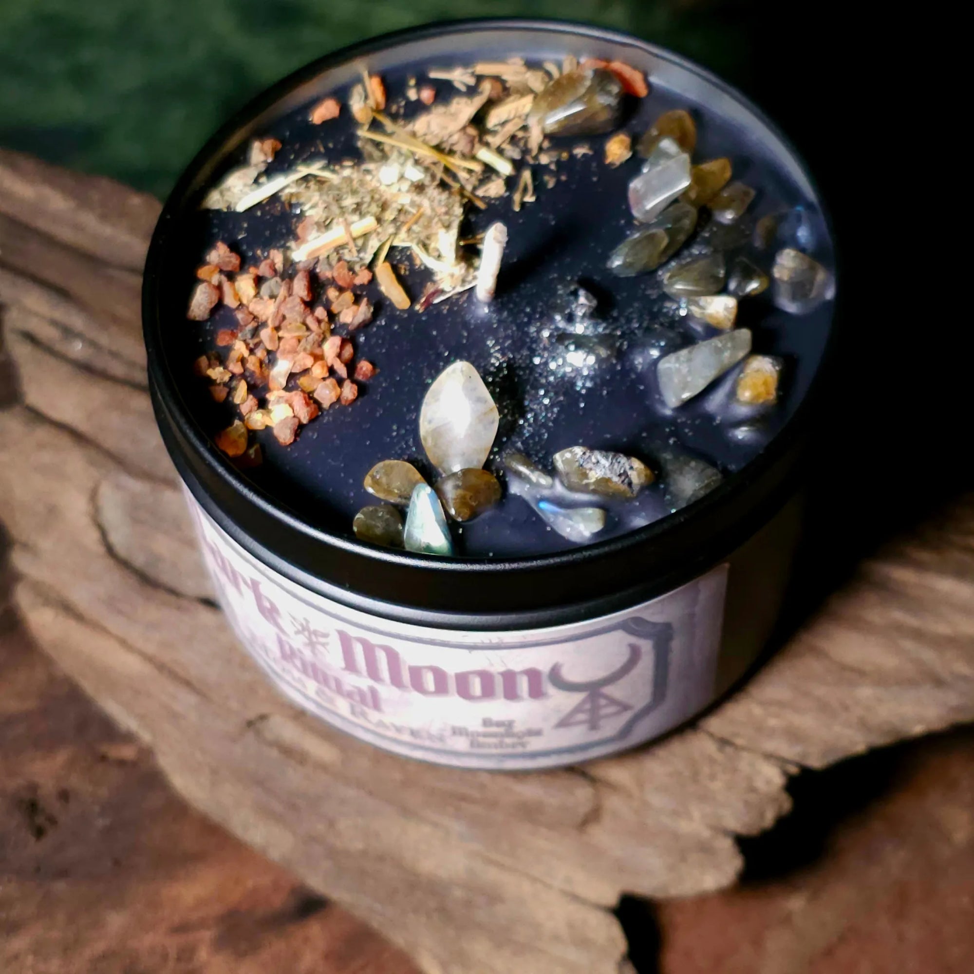 Dark Moon Ritual Candle close-up – black wax with labradorite crystals, myrrh resin, mugwort, and wormwood for shadow work and release