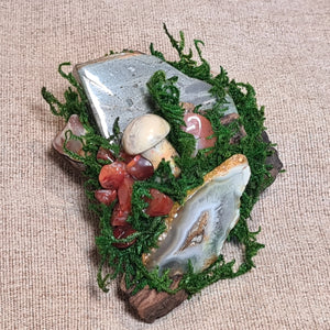 Witchy home decor sculpture blending natural moss, driftwood, and healing crystals.