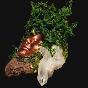 Macro detail of moss and crystals — Peridot and Clear Quartz woven into driftwood and copper for elemental grounding.