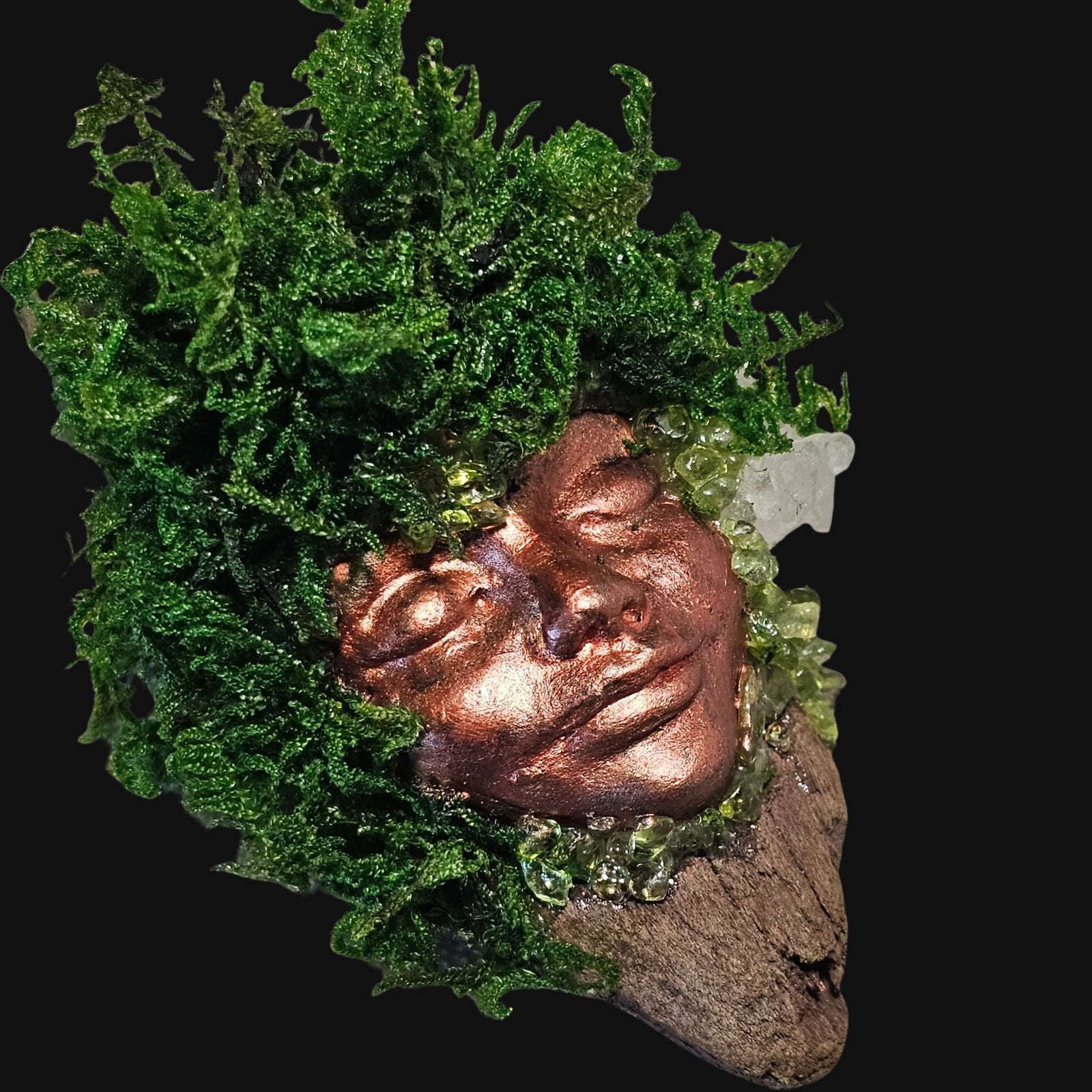 Forest Guardian sculpture with copper face, Peridot, and Clear Quartz surrounded by moss — handcrafted altar art for growth and vitality.
