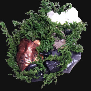 Forest Guardian sculpture with copper face, Black Tourmaline, Snowflake Obsidian, and Clear Quartz nestled in deep green moss — handcrafted altar art for protection and shadow work.