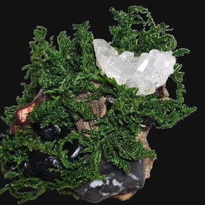 Copper-bronze Forest Guardian face surrounded by moss and dark crystals — a witchy art piece representing strength, grounding, and shadow integration.