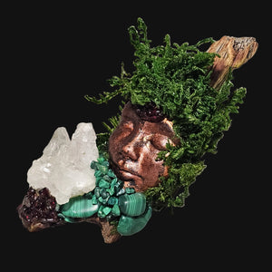 Forest Guardian sculpture featuring a copper face adorned with lush green moss, embedded with Lapis Lazuli and Clear Quartz on driftwood — handmade altar art by Moss & Raven.