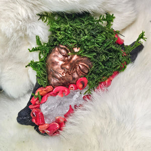 Moss covered guardian sculpture with red coral crystals and sculpted face