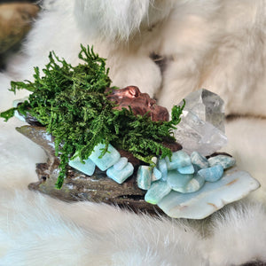 Moss covered guardian sculpture with amazonite crystal and sculpted face-side view