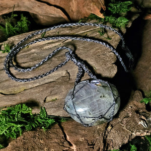 Close-up of pink flash labradorite crystal wrapped in waxed cord