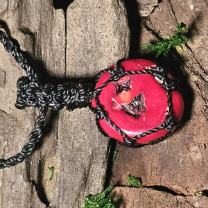 Close-up of round red coral talisman necklace