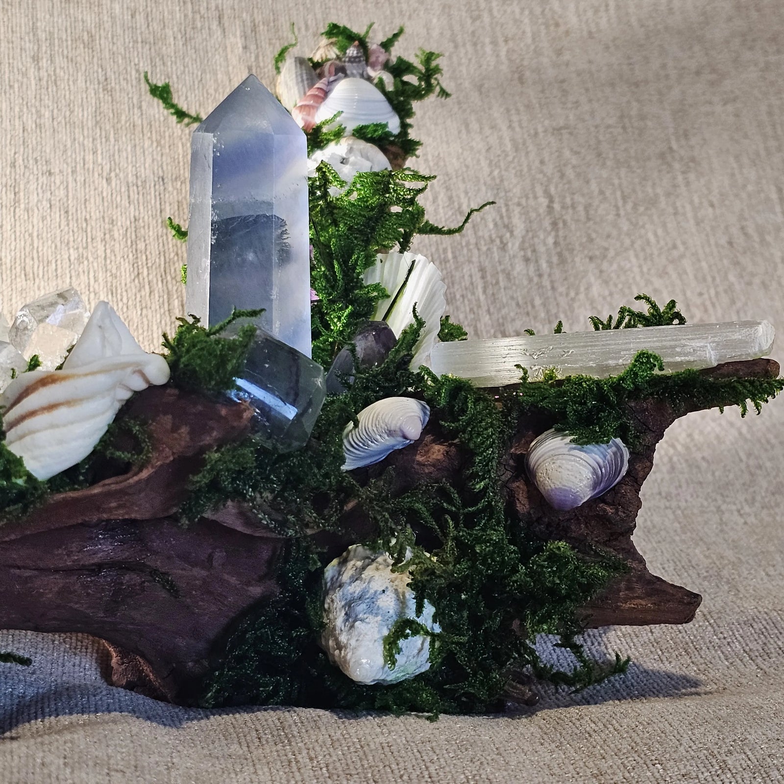 Close-up of Fluorite tower resting beside a Selenite wand and Clear Quartz cluster.