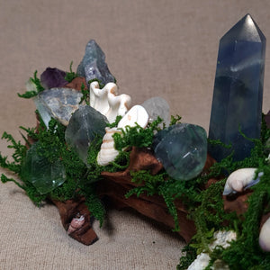 Blue Fluorite point anchored in driftwood beside a Clear Quartz cluster – handmade Crystal Forest altar.
