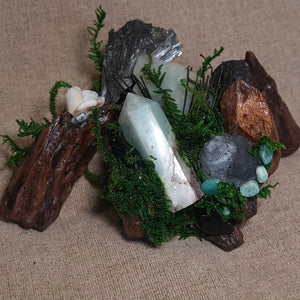 Crystal forest altar with Amazonite, Black Kyanite, Shungite, and Lava Stone on driftwood with moss – The Silent Shore by Moss & Raven.