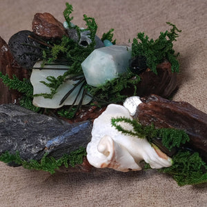 Textured forest altar with dark stones symbolising stability and calm.