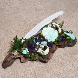 Handcrafted forest altar of driftwood, moss, and crystals symbolizing peace and intuition.
