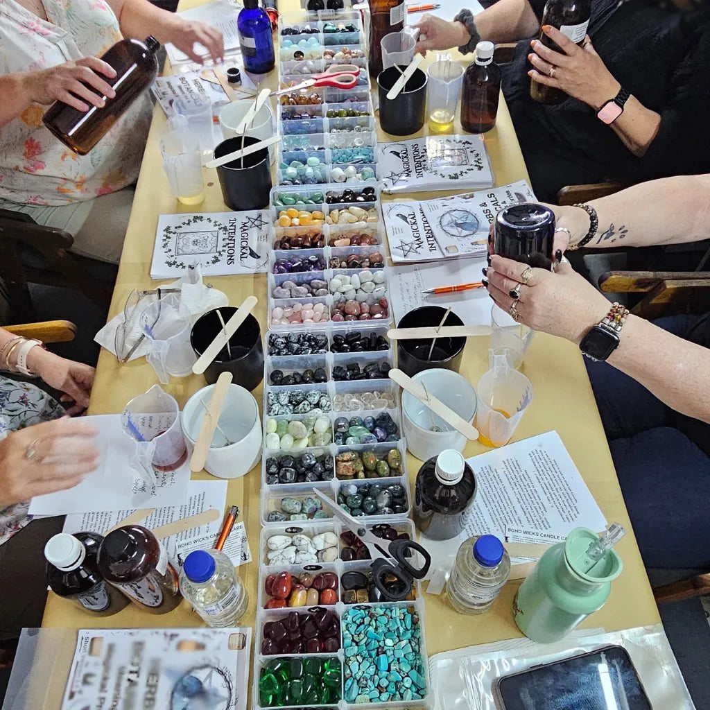 "Workshop table set up with crystal candle making supplies – wax, herbs, fragrance oils, and ritual tools"