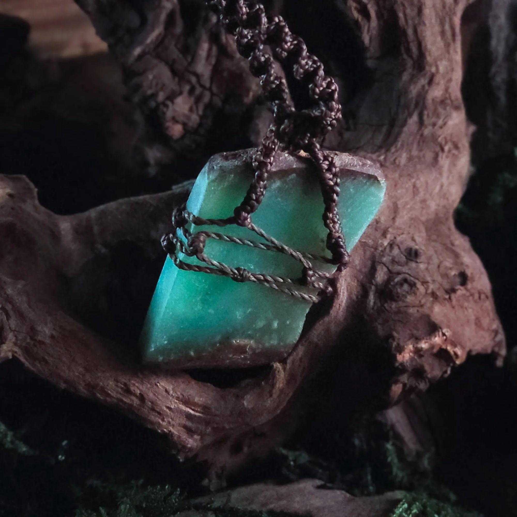 Detailed shot of bronze bead and knotwork above chrysoprase stone – handcrafted witch talisman