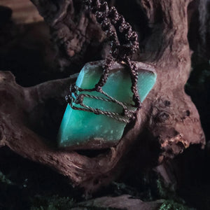 Detailed shot of bronze bead and knotwork above chrysoprase stone – handcrafted witch talisman
