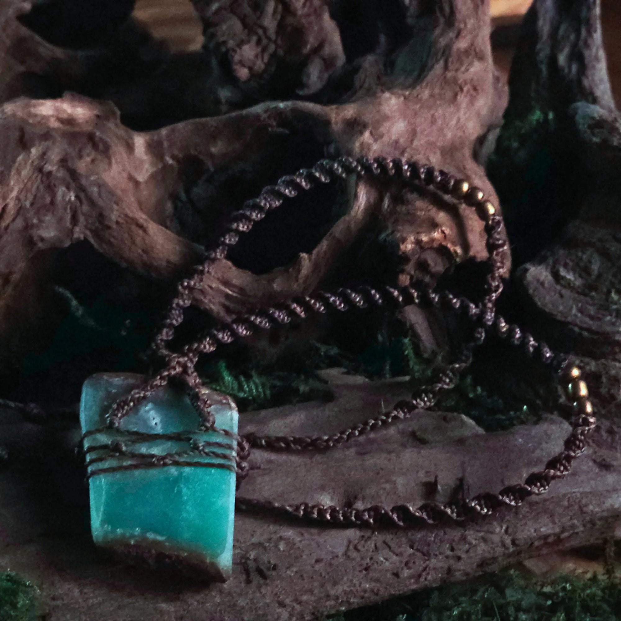 Close-up of green chrysoprase crystal woven in earthy cord – handmade ritual pendant