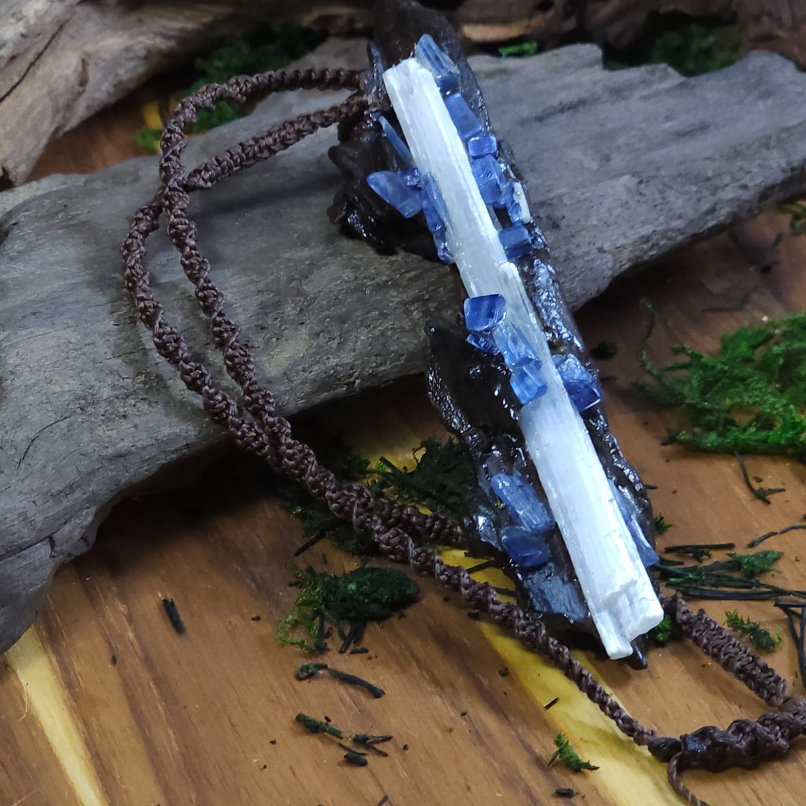 Side angle of the talisman highlighting the raised selenite and blue kyanite crystals layered along the textured wood.