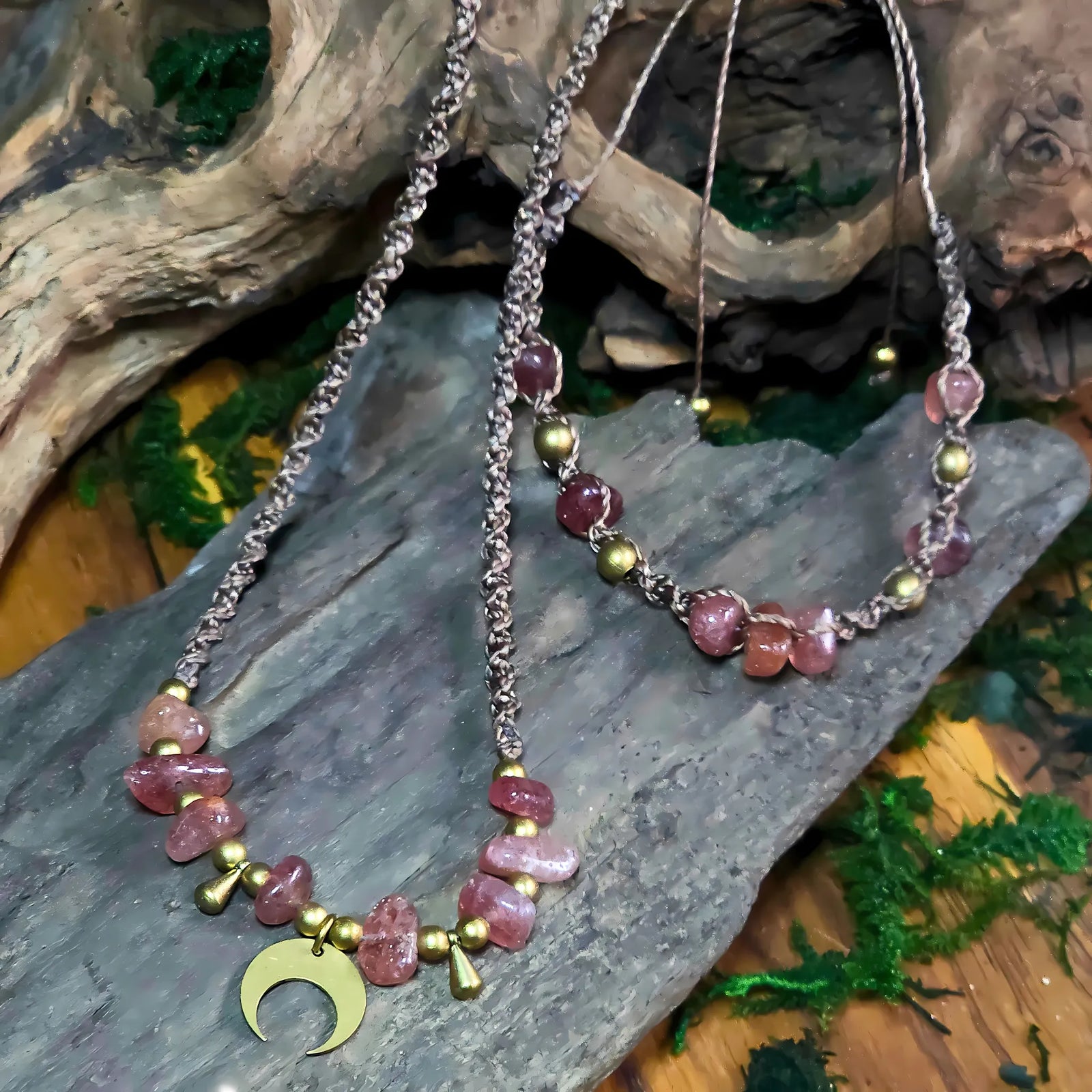 Flat lay of the full Goddess Warrior set including pendant and bracelet, styled with moss and wood elements.