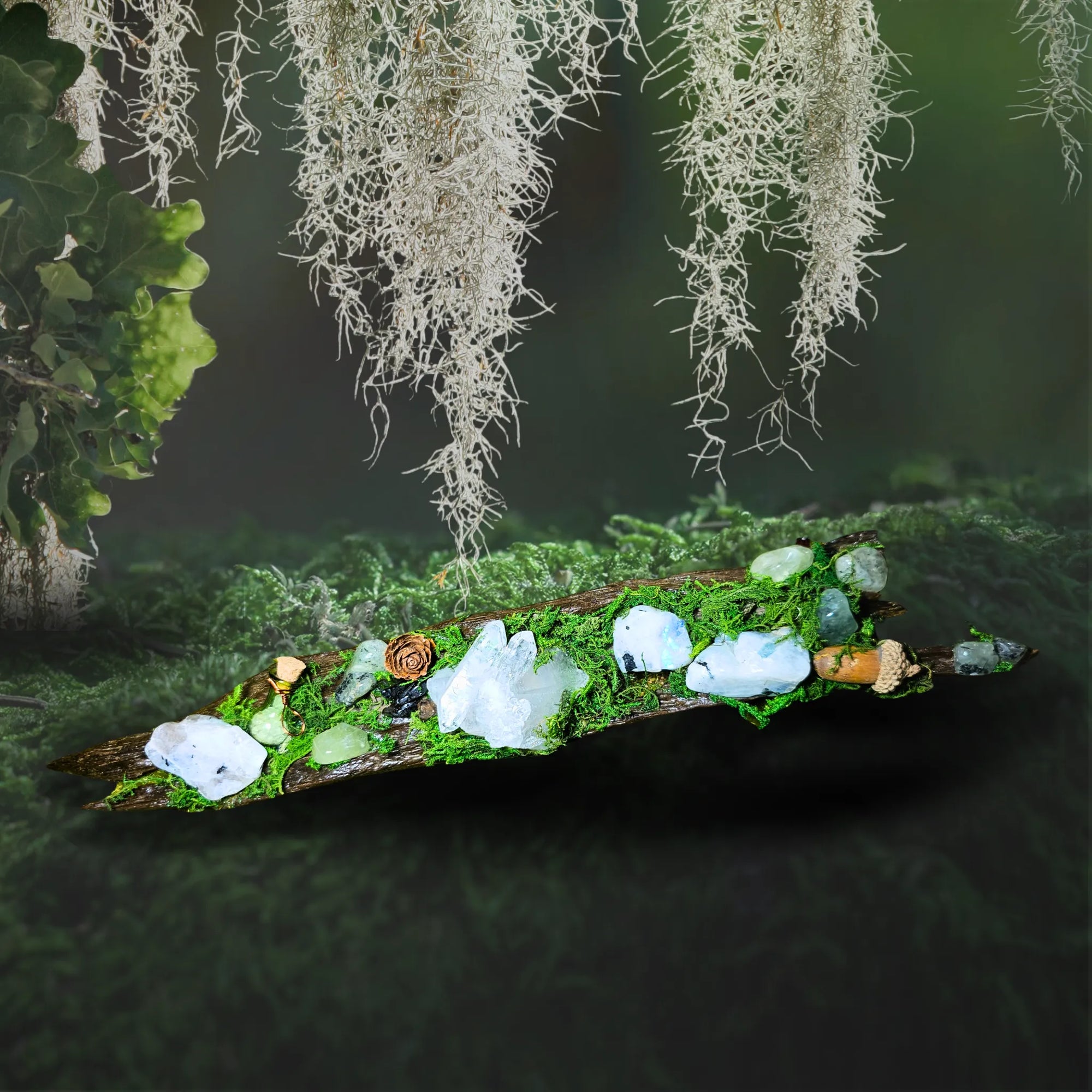 Nightborne crystal forest by Moss & Raven shown on moss and stone. Includes Clear Quartz, Moonstone, Prehnite, spell bottle, moss, acorn, pine cone, and driftwood.