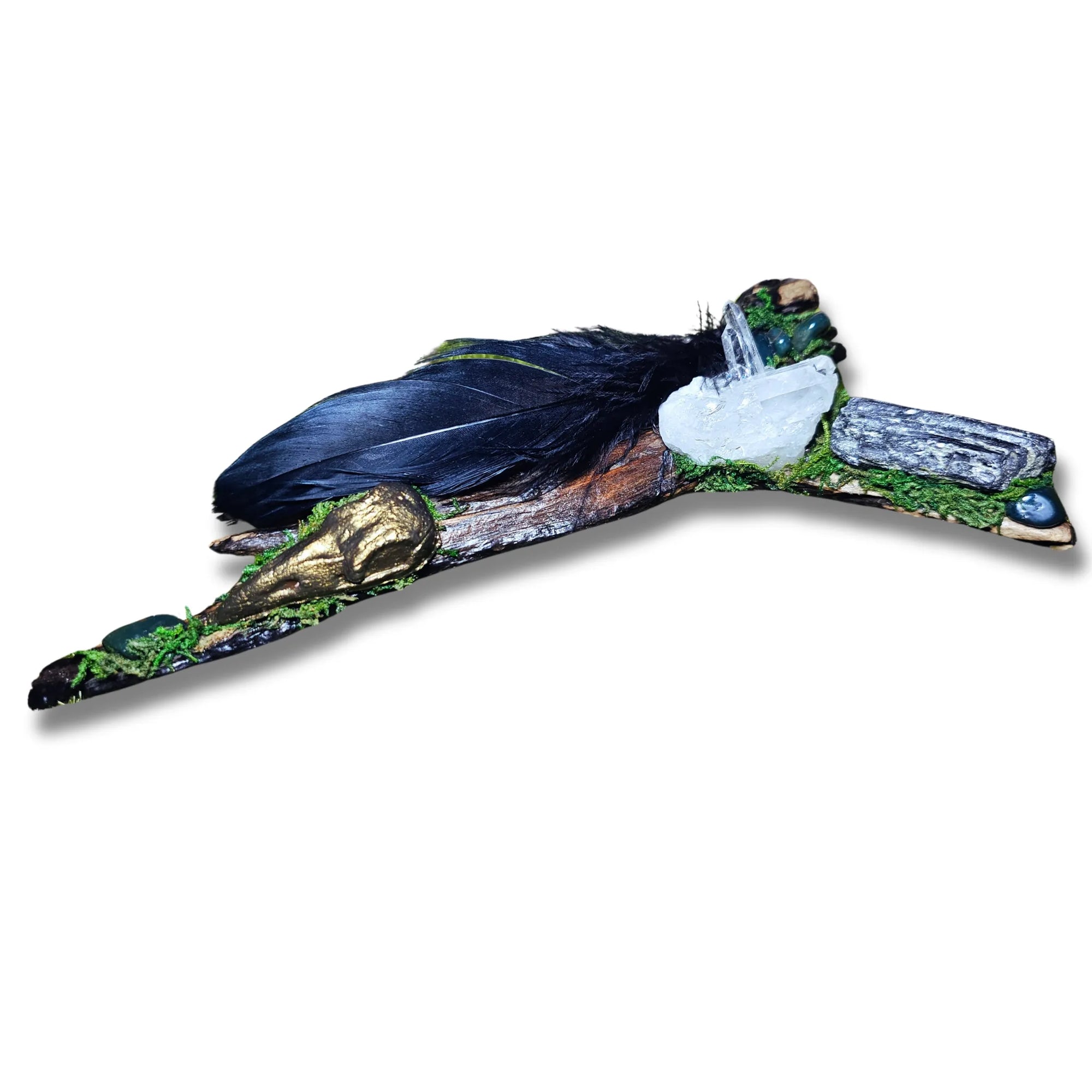 Raven’s Mark crystal forest by Moss & Raven on white background. Features sculpted gold raven head, Black Tourmaline, Bloodstone, black feather, moss, and driftwood.