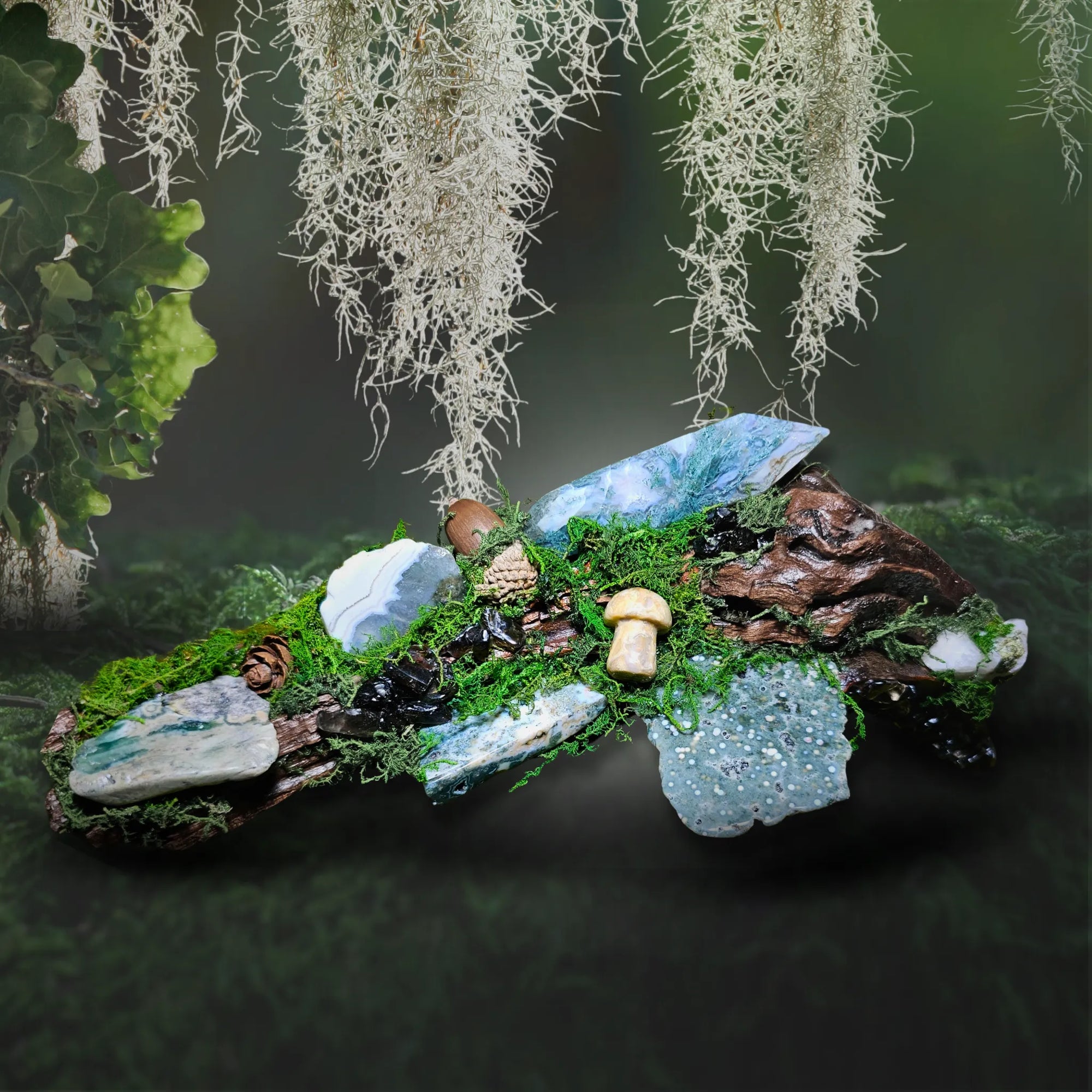 Wyrdwood crystal forest by Moss & Raven shown on moss and stone. Includes Moss Agate double terminator, Ocean Jasper, Smokey Quartz, Green Tourmaline, mushroom, acorn, pine cone, and driftwood.